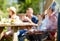 Man cooking meat on barbecue grill at summer party