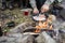 Man Cooking Meat Over Bonfire At Campsite