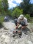 Man cooking sausages on stones.