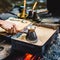 Man is cooking Turkish coffee in the box with sand under live coals