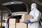 Man in coronavirus hazmat disembarking boxes with coronavirus