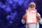 Man in costume of Santa Claus on a dark blue snowy background holds a letter in his hands