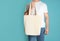 Man with cotton shopping eco bag on color background.