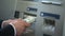 Man counting dollars withdrawn from ATM, putting cash in wallet, 24h service