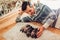 Man counting five pug dog puppies sleeping on carpet at home. Little puppies lying together on their backs