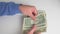 Man counting stack of small dollar banknotes