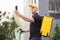 Man courier food delivery with yellow thermal backpack walks street with electric scooter