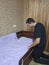 Man cover bedsheet on mattress on baby bed