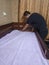 Man cover bedsheet on mattress on baby bed