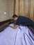 Man cover bedsheet on mattress on baby bed