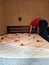 Man cover bedsheet on mattress in bedroom