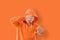 man covers face with hand on orange background, privacy protection concept