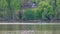 Man in crew boat on lake rowing with trees in the background