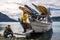 Man with crew member from scientific expedition unload the vessel docked on iceberg rock bay at wintertime to explore the island.