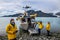 Man with crew members from scientific expedition  send a drone near the vessel docked on iceberg rock bay at wintertime to explore
