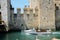 Man crosses the moat canal next to the medieval Sirmione Scaliger Castle, Italy