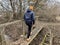 A man crosses over a wooden bridge. Rural bridge over the moat. Walk along the wooden bridge