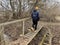 A man crosses over a wooden bridge. Rural bridge over the moat. Walk along the wooden bridge