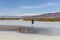 Man crosses a white mountain river on foot. Altai, Mongolia