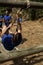 Man crossing the rope during obstacle course while people cheering him