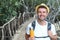 Man crossing wooden footbridge in the tropical jungle