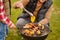 Man crouched near barbecue with vegetables
