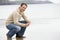 Man crouching on beach