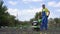 Man cultivates the ground in the garden with a tiller, preparing the soil for sowing