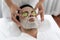 Man customer indulges in rejuvenating with cucumber facial care. Quiescent