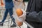 Man customer in protective rubber gloves putting orange in a plastic transparent disposable bag in grocery store, supermarket.