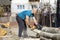 Man cut with saw. Dust and movements. Woodcutter saws tree with chainsaw on sawmill.