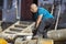 Man cut with saw. Dust and movements. Woodcutter saws tree with chainsaw on sawmill.