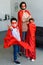 man and cute little sons in red superhero costumes