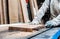 A man cuts a board on a stationary circular saw in a carpentry workshop. close-up