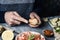 Man cuts a bread bun to prepare a vegan sandwich