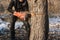 A man cuts a chainsaw trunk and branches of a tree.