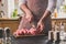 Man cuts of fresh piece of beef on a wooden cutting board in the home kitchen