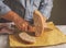 A man cuts freshly baked whole-wheat bran bread with a sharp knife