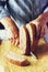 A man cuts freshly baked whole-wheat bran bread with a sharp knife