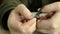 The man cuts an indefinite trims fingernails with nail scissors