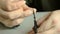 The man cuts an indefinite trims fingernails with nail scissors