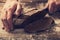 man cuts rye bread on a flour table.