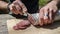 A man cuts some slices of salami