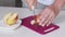 The man is cutting apples into wedges. Close-up shot