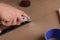 Man cutting cardboard with utility knife and ruler, closeup