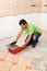 Man cutting ceramic floor tile