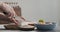 Man cutting feta cheese on olive wood board for greek salad