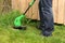 Man cutting the grass with electric trimmer