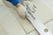 Man is cutting gypsum board with knife.