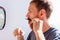 Man cutting his own beard and mustache with scissors and comb. Caucasian red bearded male trimming hair on face at home